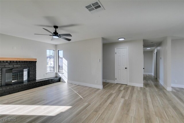 unfurnished living room featuring ceiling fan, a fireplace, and light hardwood / wood-style floors