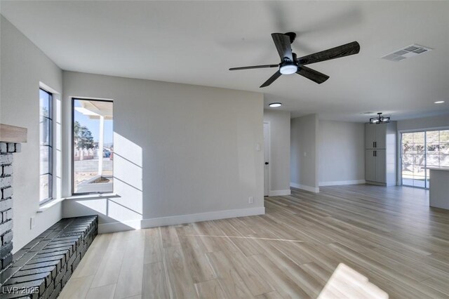 unfurnished living room with ceiling fan, plenty of natural light, and light hardwood / wood-style flooring