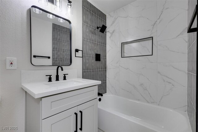 bathroom with tiled shower / bath combo and vanity