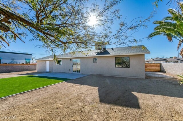 rear view of house featuring a patio area and a yard