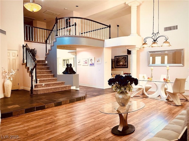 living room featuring a high ceiling, a chandelier, and hardwood / wood-style flooring