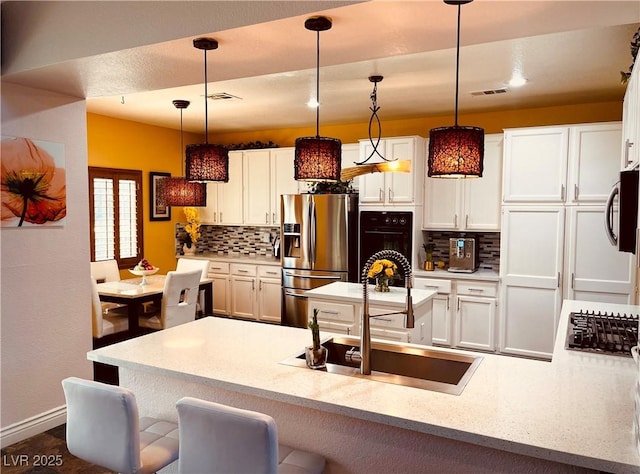 kitchen with hanging light fixtures, stainless steel appliances, and tasteful backsplash