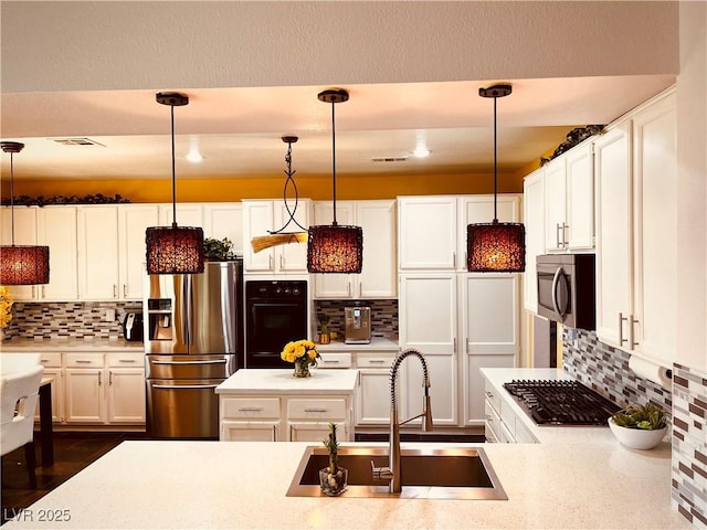 kitchen featuring decorative light fixtures, appliances with stainless steel finishes, and sink