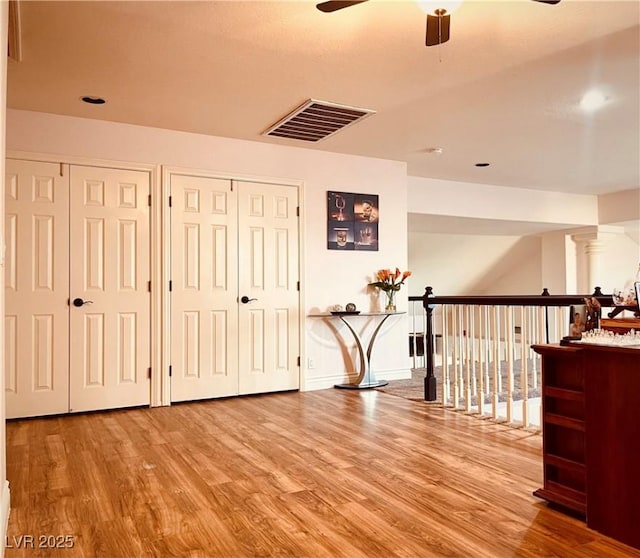 corridor featuring wood-type flooring and ornate columns