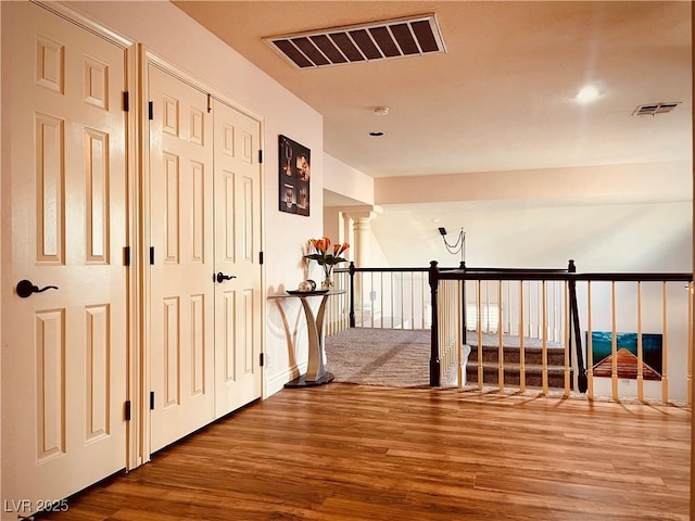 hall featuring decorative columns and hardwood / wood-style flooring