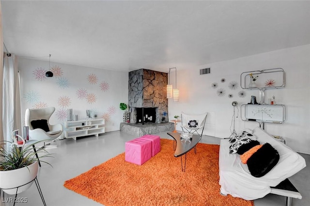 living room with a fireplace and concrete flooring