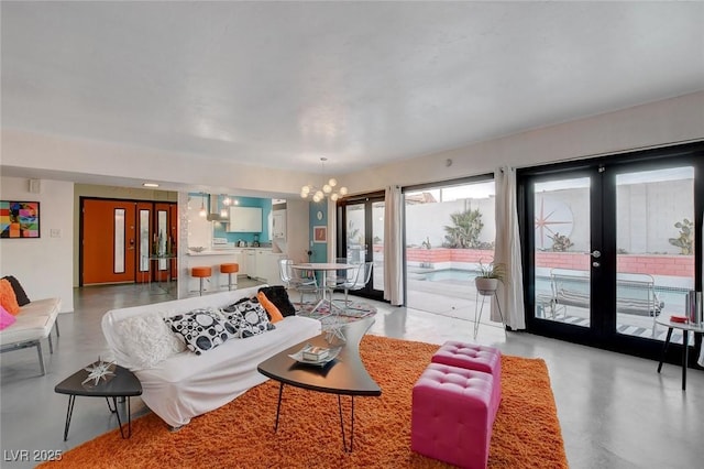 living room featuring a chandelier and french doors