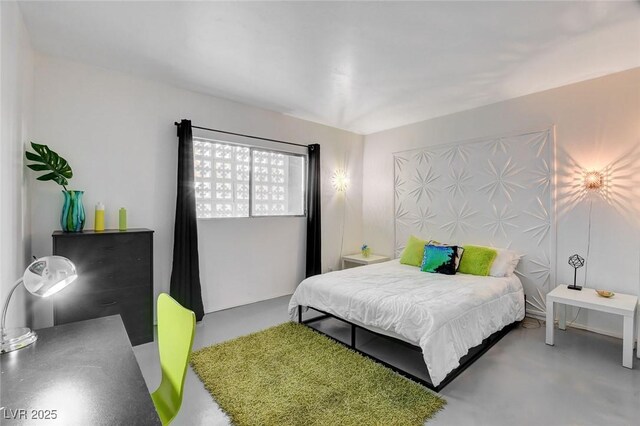 bedroom featuring concrete flooring