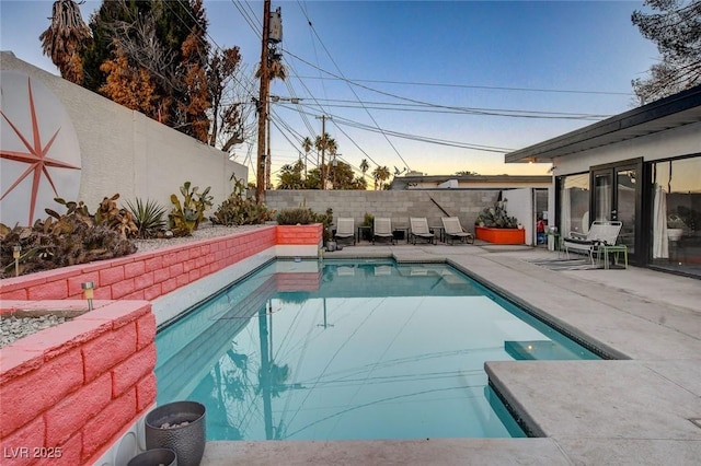 pool at dusk with a patio