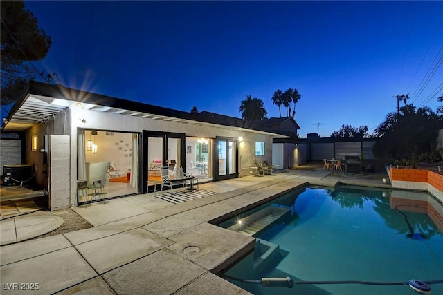 pool at dusk with a patio