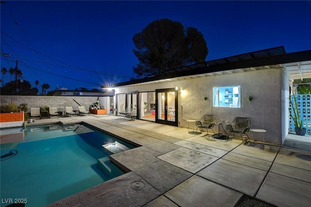 pool at twilight with a patio area