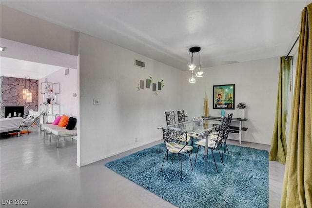 dining room featuring concrete flooring and a fireplace