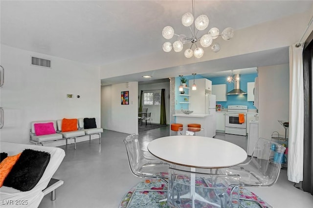 dining room with concrete floors and a notable chandelier