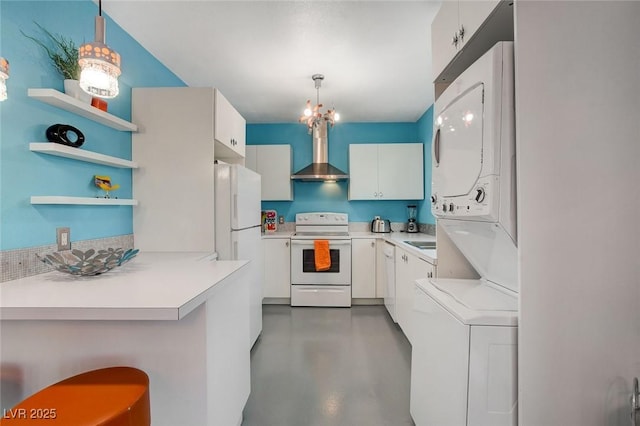 kitchen featuring decorative light fixtures, a notable chandelier, white appliances, white cabinets, and wall chimney exhaust hood