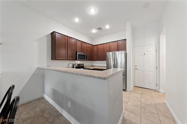 kitchen with light tile patterned floors, kitchen peninsula, dark brown cabinets, and stainless steel appliances