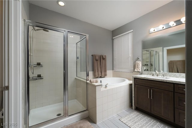 bathroom featuring tile patterned flooring, shower with separate bathtub, and vanity