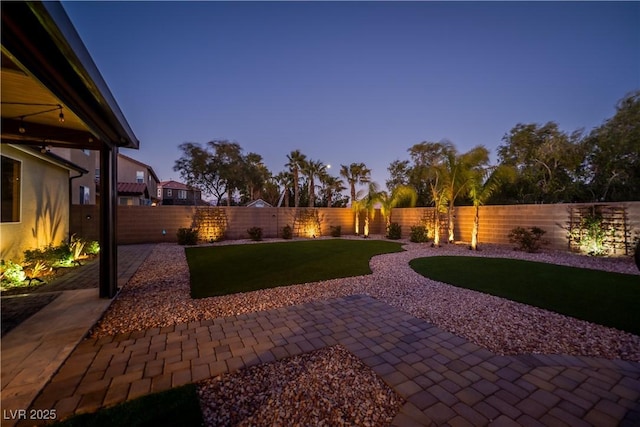 yard at dusk featuring a patio