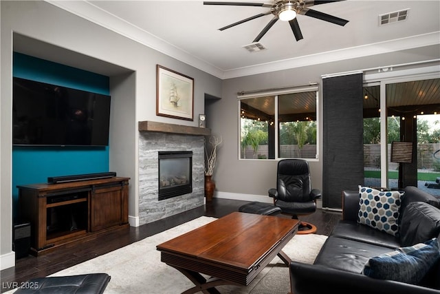 living room featuring ceiling fan, plenty of natural light, dark hardwood / wood-style floors, and a fireplace