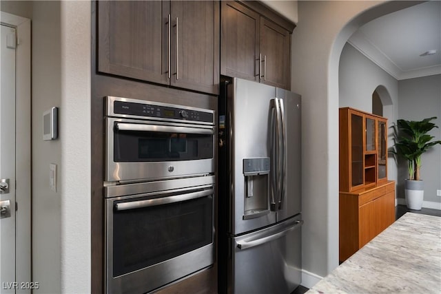 kitchen featuring dark brown cabinets, ornamental molding, and stainless steel appliances