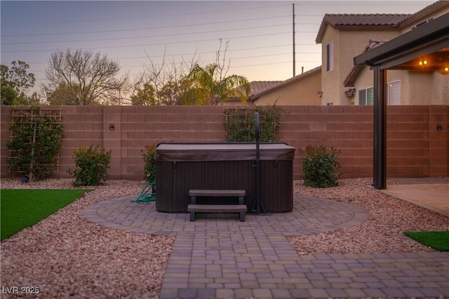 patio terrace at dusk with a hot tub