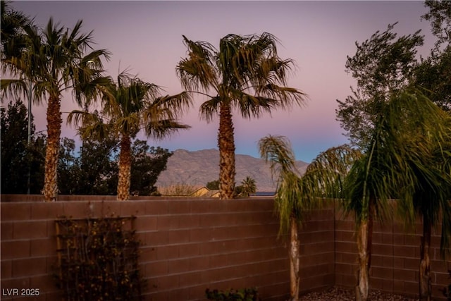 yard at dusk featuring a mountain view