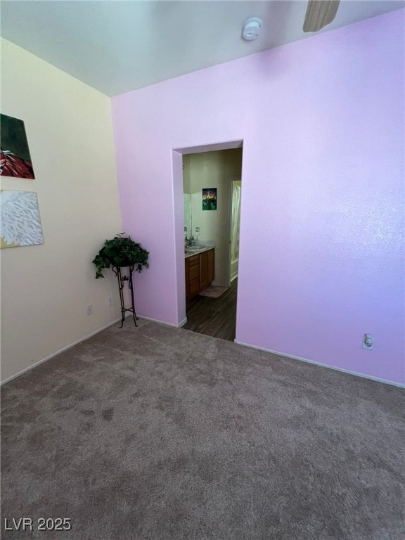 spare room with ceiling fan and dark carpet