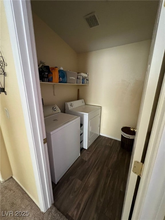 clothes washing area with washer and dryer and dark wood-type flooring