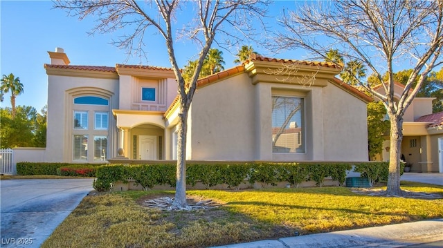 mediterranean / spanish home with a front yard