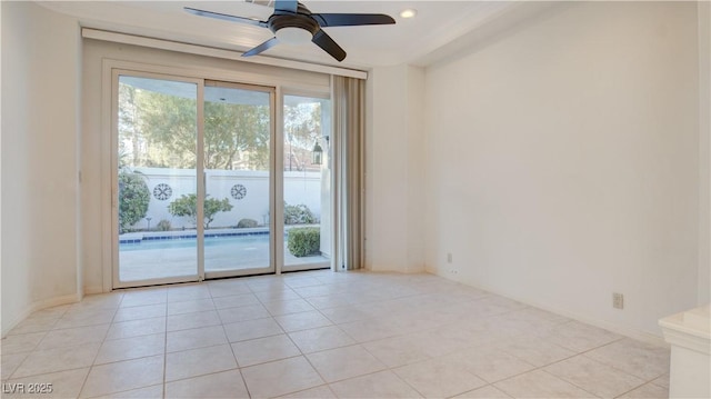 tiled empty room featuring ceiling fan