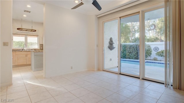 tiled empty room with ceiling fan and sink