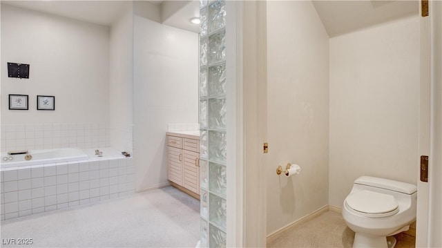 bathroom featuring toilet, tiled tub, and vanity