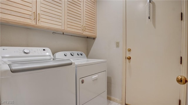 washroom with cabinets and washing machine and dryer