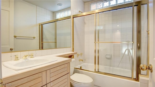 full bathroom featuring toilet, vanity, and combined bath / shower with glass door