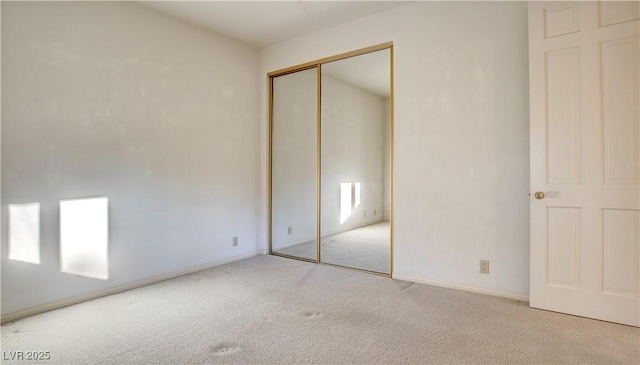 unfurnished bedroom with a closet and light carpet