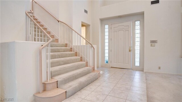 foyer entrance with a high ceiling and light tile patterned floors