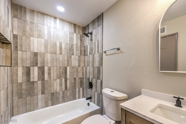 full bathroom featuring toilet, vanity, and tiled shower / bath