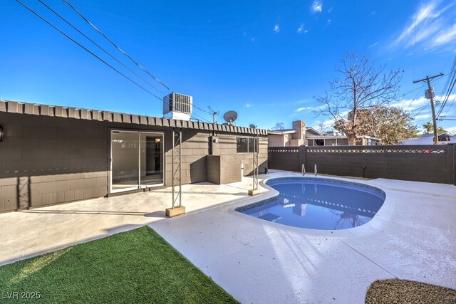 view of swimming pool featuring central air condition unit and a patio