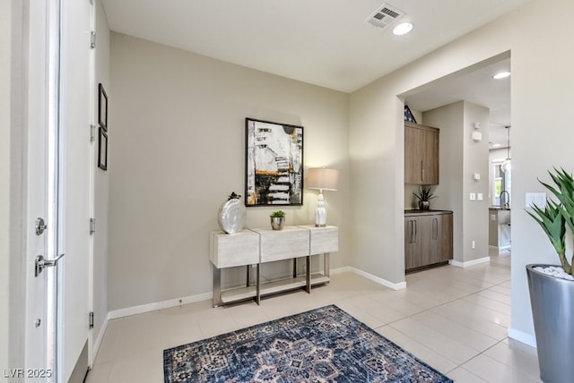 hallway with sink and light tile patterned flooring