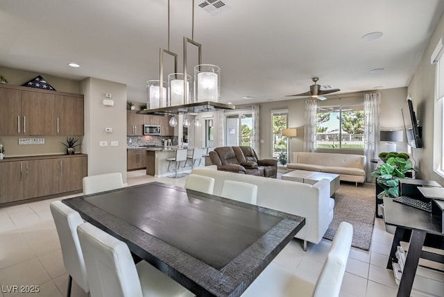 tiled dining area with ceiling fan