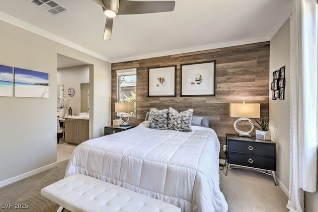 carpeted bedroom featuring ceiling fan, crown molding, ensuite bathroom, and wood walls