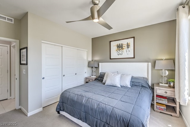 carpeted bedroom with ceiling fan and a closet