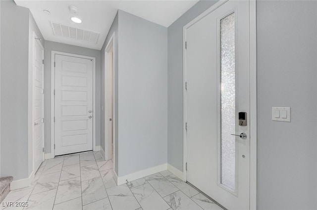 hallway featuring marble finish floor, visible vents, and baseboards