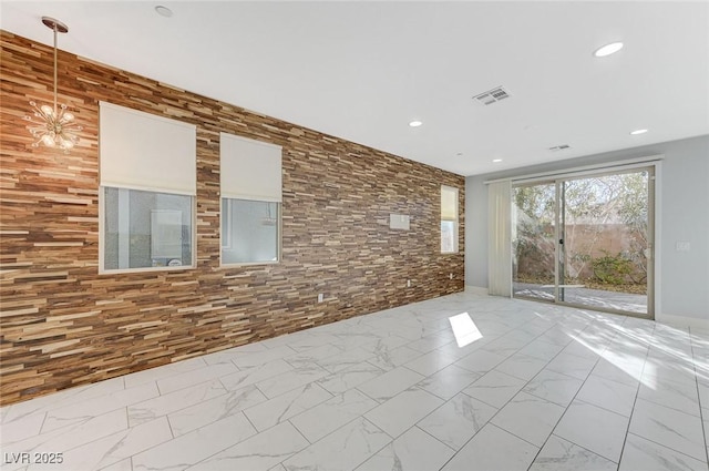 unfurnished room featuring an inviting chandelier