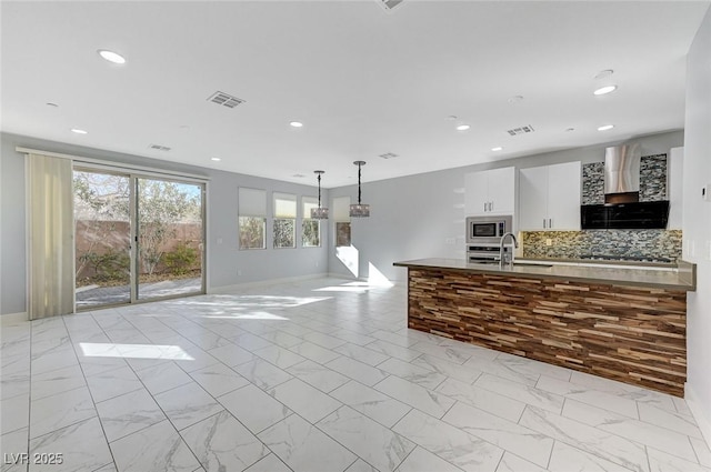 kitchen with marble finish floor, wall chimney exhaust hood, visible vents, and stainless steel appliances