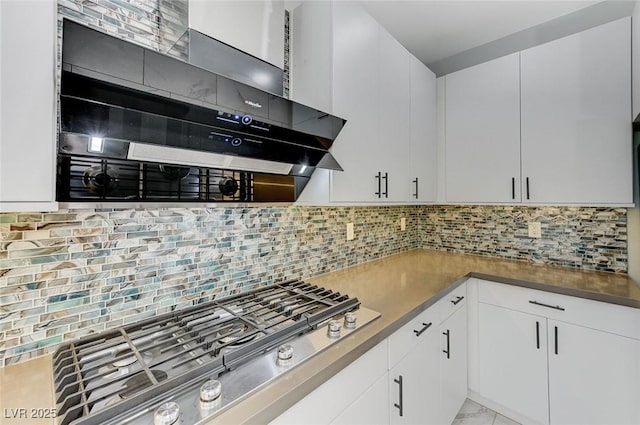 kitchen featuring ventilation hood, white cabinetry, stainless steel gas cooktop, and tasteful backsplash