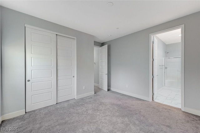 unfurnished bedroom featuring ensuite bathroom, carpet floors, a closet, and baseboards