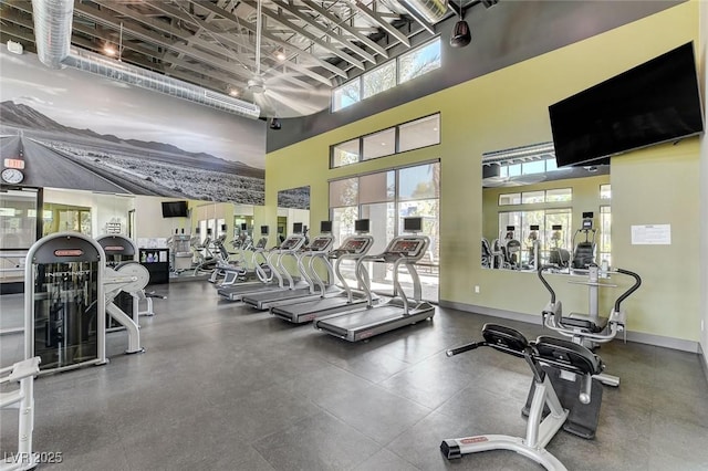 exercise room featuring a towering ceiling