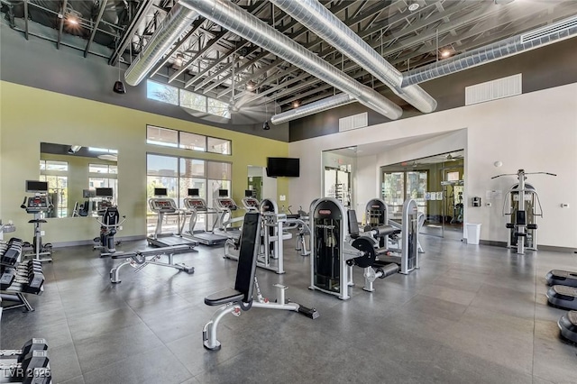 exercise room featuring a towering ceiling