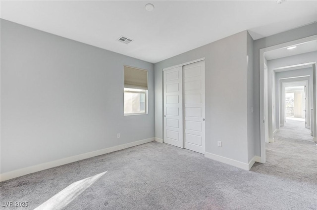 unfurnished bedroom featuring visible vents, a closet, baseboards, and carpet flooring