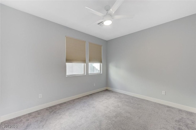 carpeted empty room featuring a ceiling fan and baseboards